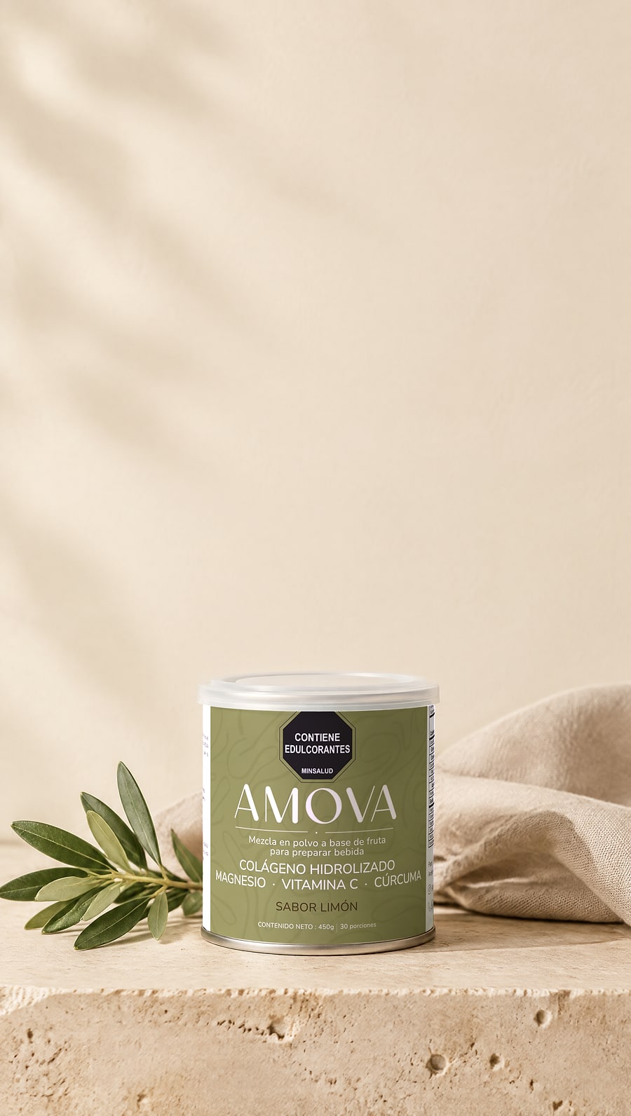 Envase de AMOVA sobre una losa de piedra clara, junto a una rama de olivo, con luz cálida de la mañana. Etiqueta verde salvia con el sello «Contiene edulcorantes», el nombre AMOVA y el texto «Colágeno hidrolizado, magnesio, vitamina C, cúrcuma. Sabor limón. Contenido neto 450 g, 30 porciones».